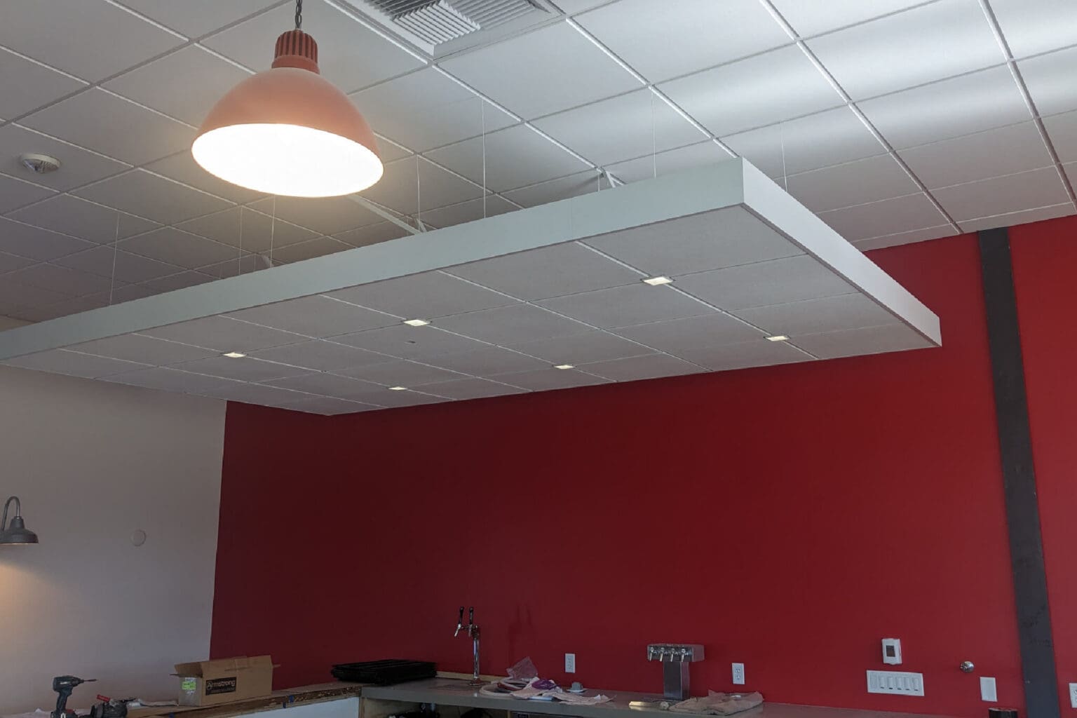 Modern kitchen with red accent wall.